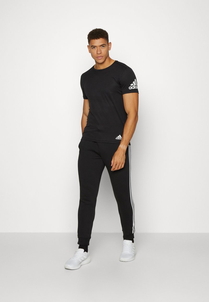 adidas Sportswear adidas Sportswear ESSENTIALS TAPERED CUFF 3 STRIPES PANTS - Tracksuit bottoms - black white Neueste Mode